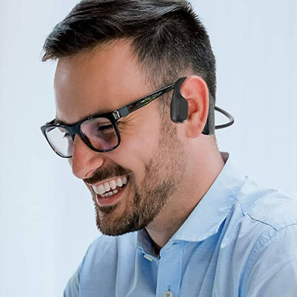 Man wearing wireless bone conduction headphones while smiling and enjoying a conversation.