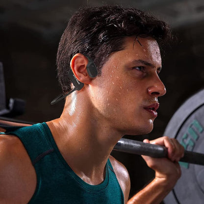 Man lifting weights while wearing wireless bone conduction headphones for an open ear listening experience.